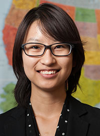 Profile of Yoky (Shiayao) Yu as she stands in front of a map.