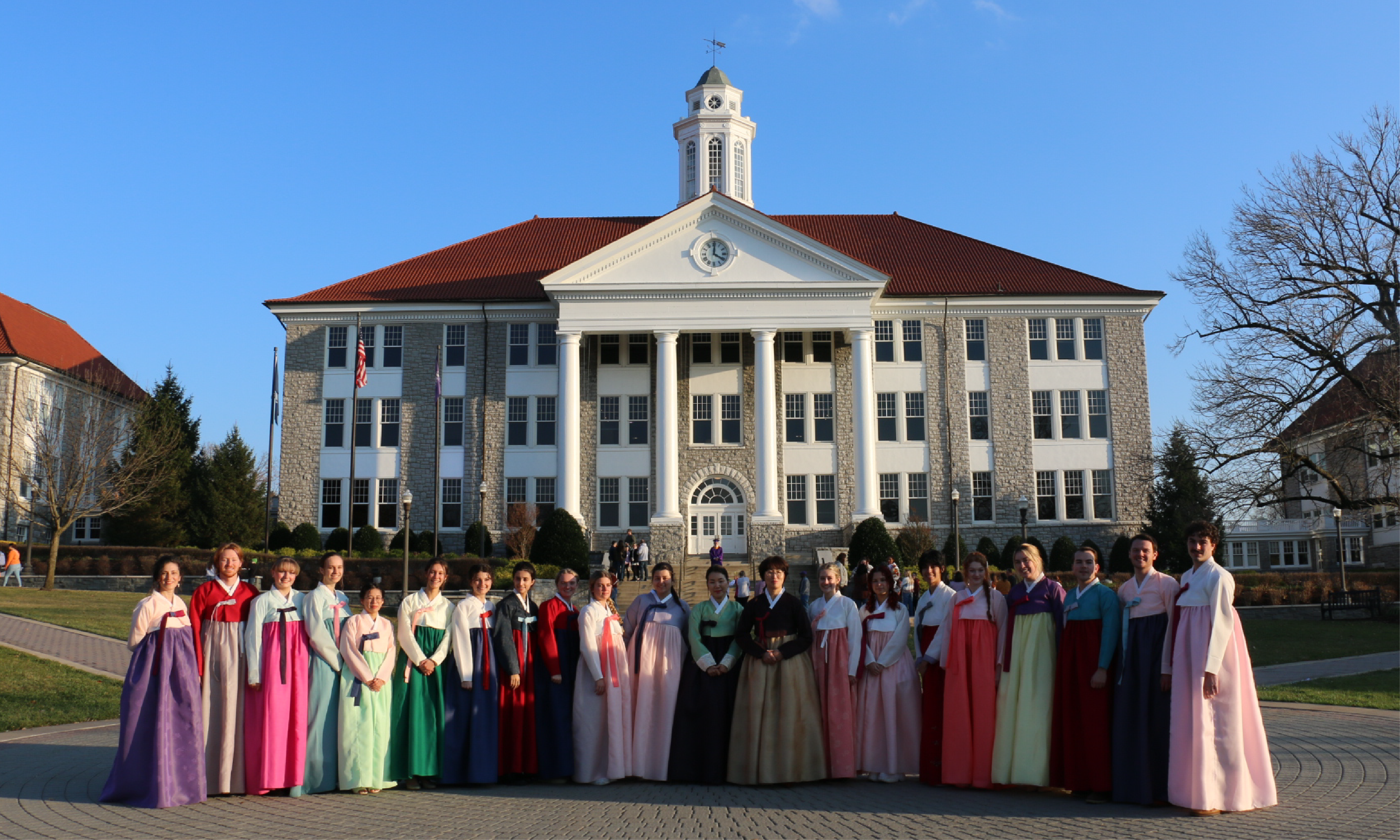 A group of students from the masterclass pose in front of Wilson Hall with their hanbok on.