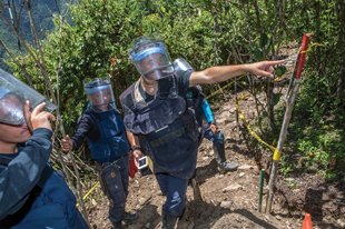 Jefferson Martinez, from FARC-EP, points out to members of the Colombian military’s Humanitarian Demining Brigade an area where they might find more landmines in a minefield in Antioquia, Colombia. Image courtesy of Norwegian People's Aid/Giovanni Diffidenti