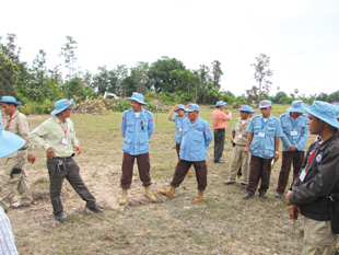 A group of men in blue uniforms standing around a field.