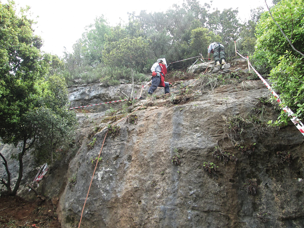 Demining teams working on a large rock face in Lebnon.