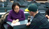 Dr. Hui He Sono consulting with a student in a lecture hall - 2017