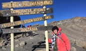 Matthew Fracasso standing by Mt. Kilimanjaro sign - 2016