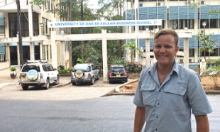 Matthew Fracasso in Tanzania in front of the local Business School