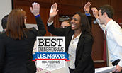MBA Students high fiving at a workshop - 2016 - with US News 2018 Badge