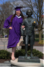 picture of tutor Becky Rosen in graduation gear next to James Madison statue
