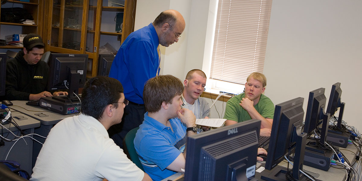 A Compute Science professor instructs students in a lab