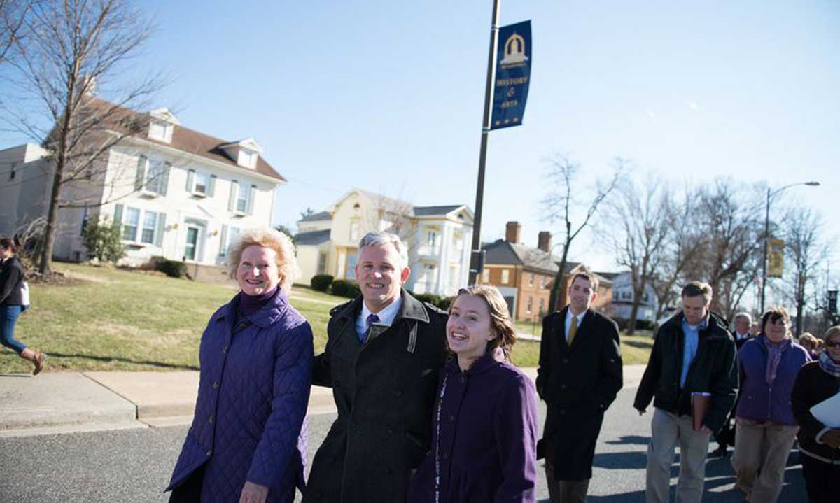 The Alger family, Jon, Mary Ann and daughter Eleanor, lead the ceremonial walk from campus to Harrisonburg's Court Square followed by approximately 200 students, faculty, staff and community members. 