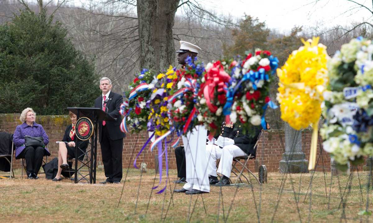 JMU president Jon Alger speaks amid a collection of wreaths to commemorate the 262nd anniversary of the birth of James Madison on Saturday at Montpelier. 
