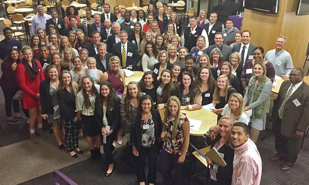 Current and former JMU student-athletes gather for a group photo.