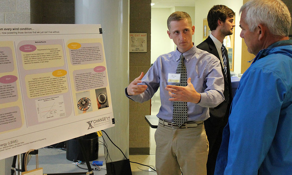 Student discusses poster with a visitor