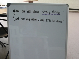 White board with text "you are not alone. stay strong. just call my name, and I'll be there"