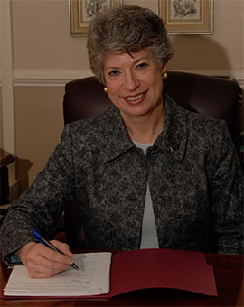 Formal portrait of Dr. Linda Cabe Halpern seated at desk