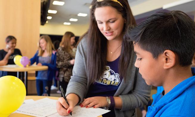 Photo of JMU student working with Valley Scholars during Shark-Tank simulation event