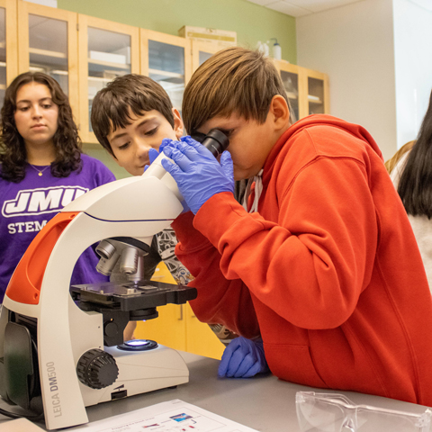 Local high school students getting hands-on experience with a microscope