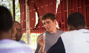 Brian Caperton ('13) shares in a game of cards during JMU Alternative Spring Break trip in Jamaica