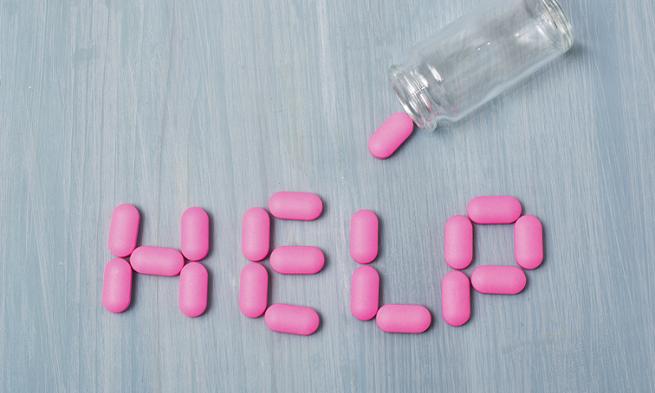 Photo of pill bottle spilling out pills to spell the word help
