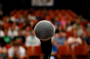 Picture of an open mic in front of an audience