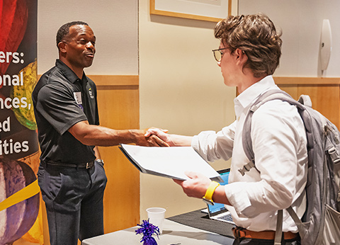 a student shakes hands with an employer
