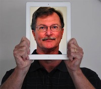 Photo of Dr. Richard Ingram holding in front of his face an iPad with a picture of himself.