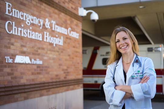 JMU alumna Melissa Cummings stands outside the Emergency & Trauma Center at Christina Hospital, where she is completing her three year residency