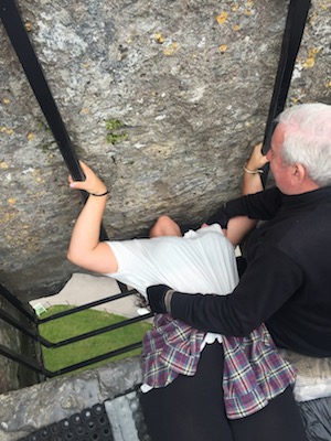 Kennedy kissing the Blarney Stone in Cork, Ireland