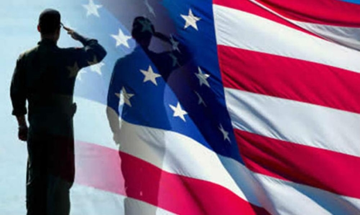 Two silhouettes of military personnel saluting super-imposed over a rippling US flag