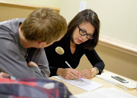 photo of woman tutoring a student