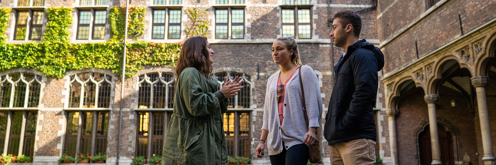 Three study abroad students talk in a courtyard in Antwerp, Belgium.