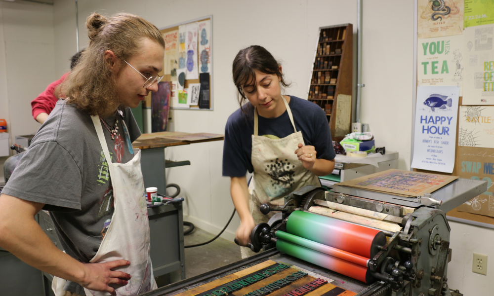 Two students use the printing press.