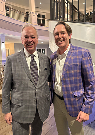 Two men in suits posing for a photo.
