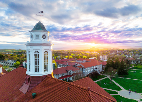 A cloudy sky lit up by the sunset, seen from beside JMU's Wilson Hall and iconic cupola. 