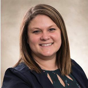 A portrait of Sarah Caban, smiling widely in professional wear.
