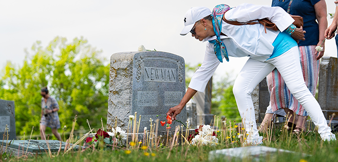 A Newman family member lays flowers at the grave of George Newman and his wife, Mary.