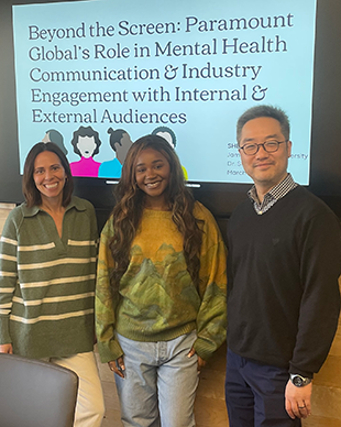 Three people stand in front of a projected screen that reads Beyond the Screen: Paramount Global's Role in Mental Health Communication & Industry Engagement with Internal & External Audiences