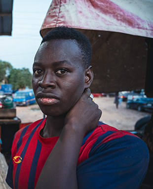 A Black man rubs his neck with his hand.