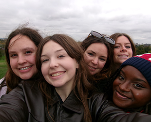 Five girls taking a selfie together.