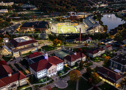 An aerial view of Wilson Hall and Bridgeforth Stadium as night falls.