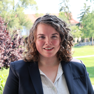 A woman in a blazer and collared shirt. 
