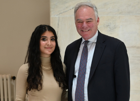 Two people, Isabella Santos (left) and Senator Tim Kaine (right) stand next to each other. 