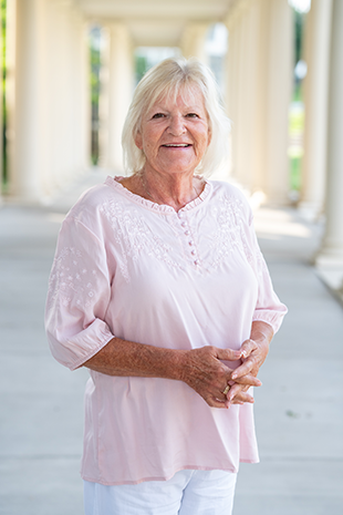 A woman in a pale pink blouse.