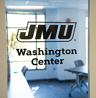 A glass door with a black vinyl applique reading JMU Washington Center.