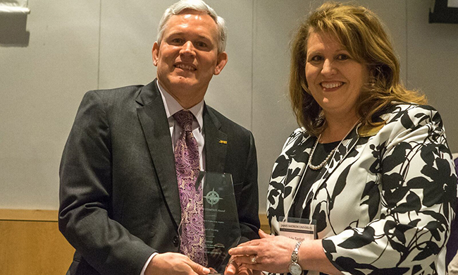 Julie Sanford accepts award from President Alger