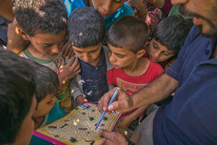 Children use EORE materials that show how to avoid mines and other EO. It is essential to field test new materials, messages, and approaches when creating and delivering EORE.