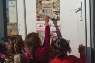 Internally displaced persons (IDP) camp in Dohuk, Iraq. Yazidi children are recognizing EO they encountered while they fled their home areas. CL teams in Duhok generally focus on cluster munitions and conventional mines, but include information on improvised mines where relevant for IDPs from Ninewa and other governorates. Image courtesy of Sean Sutton/MAG.