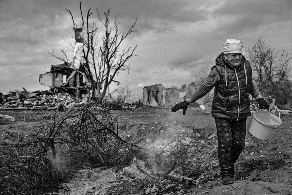 Tanya, a villager, walks past her house destroyed in the explosion.