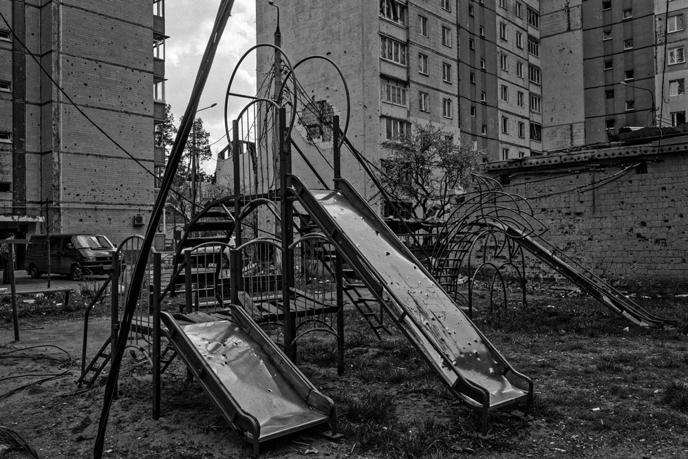 A children's playground hit with cluster munitions. The unmistakable marks including fragmentation "splatter" can be seen all around the area.