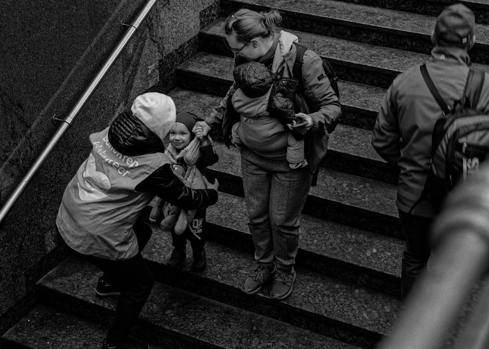 Women carry children down the stairs of a train station