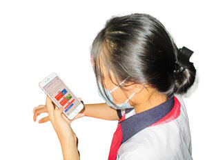 An 8th grade student at Hai Lam Primary and Secondary School, views risk education materials on her mobile phone.