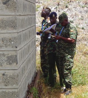A group of regional PSSM course participants assessing the outside security parameters of an ammunition storage facility during a practical exercise.